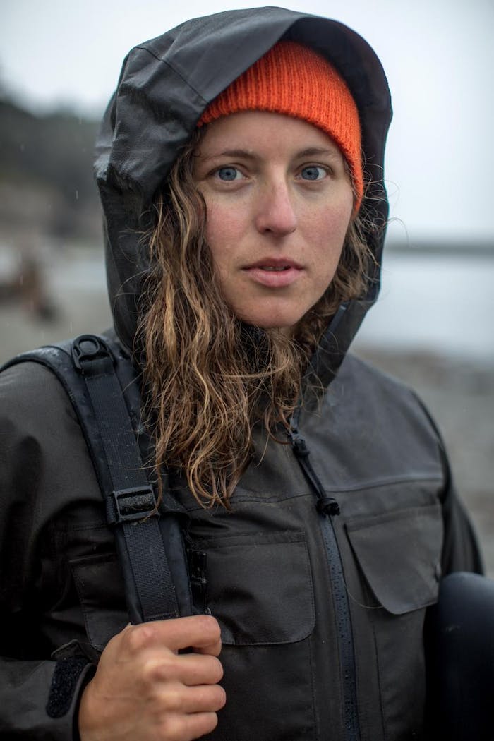 claire portrait in black raincoat with orange hat