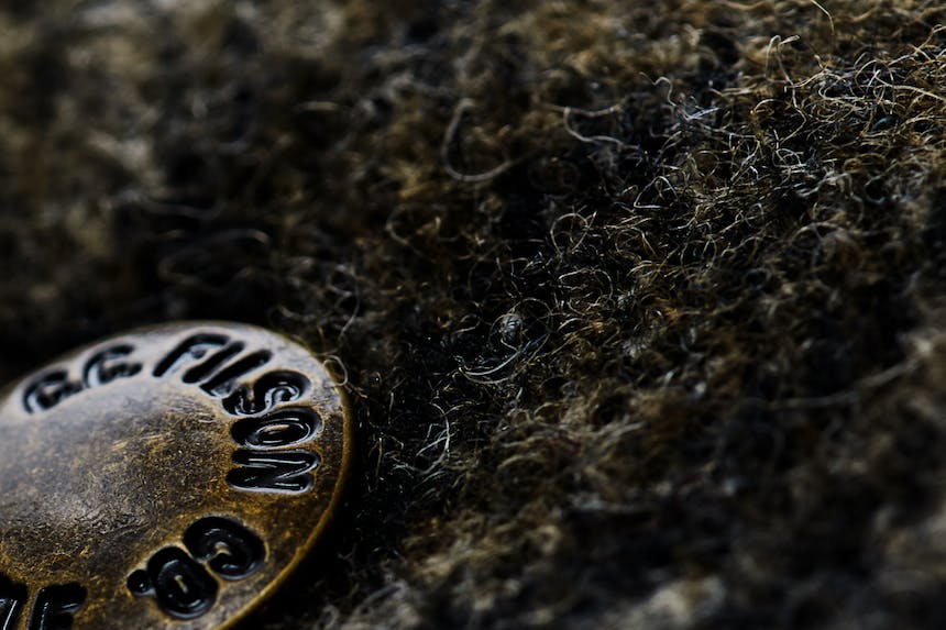 a close up image of a Filson wool coat with the bronze button reading Filson Co