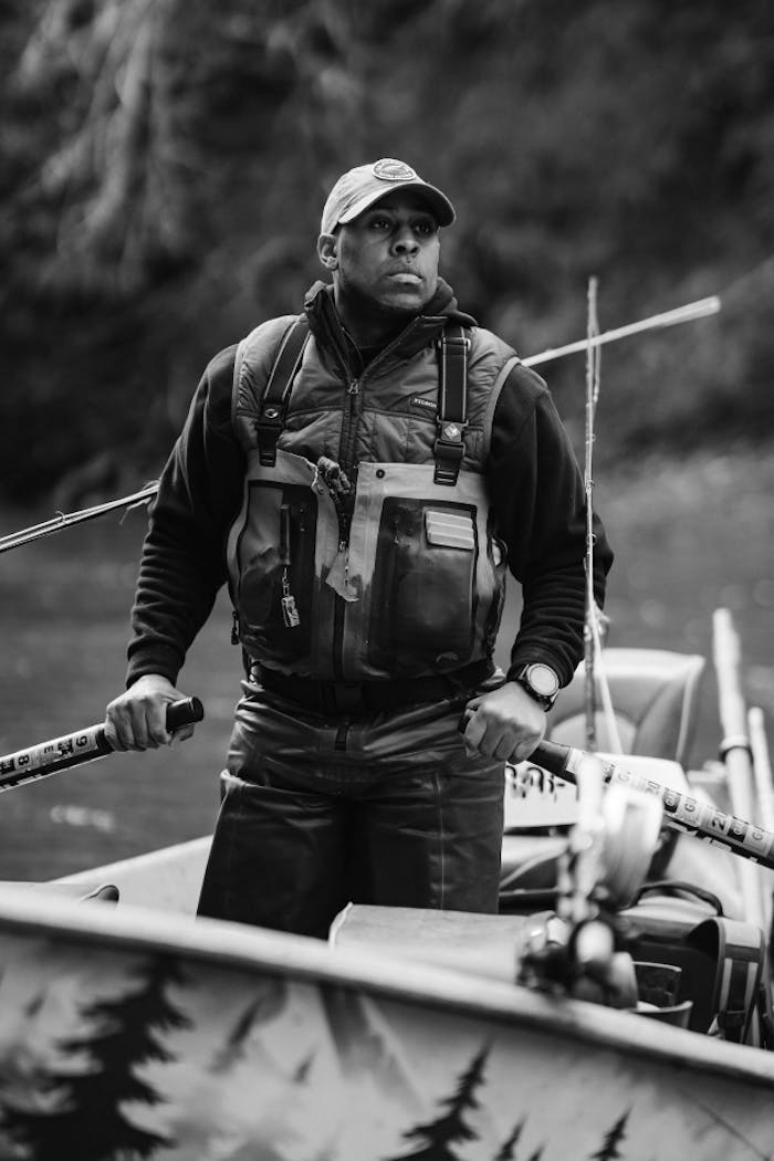 man holding oars while standing in boat