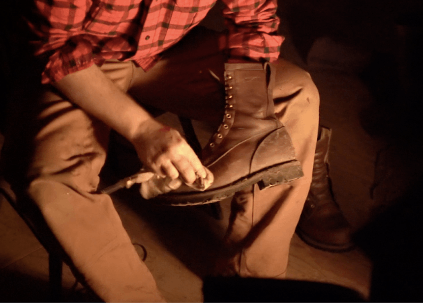 hand holding boot administering polish to brown leather boot