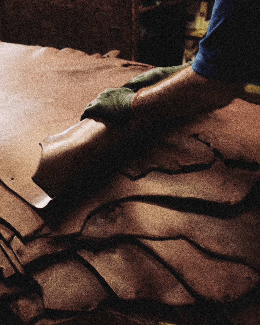 Hands rolling leather hides.
