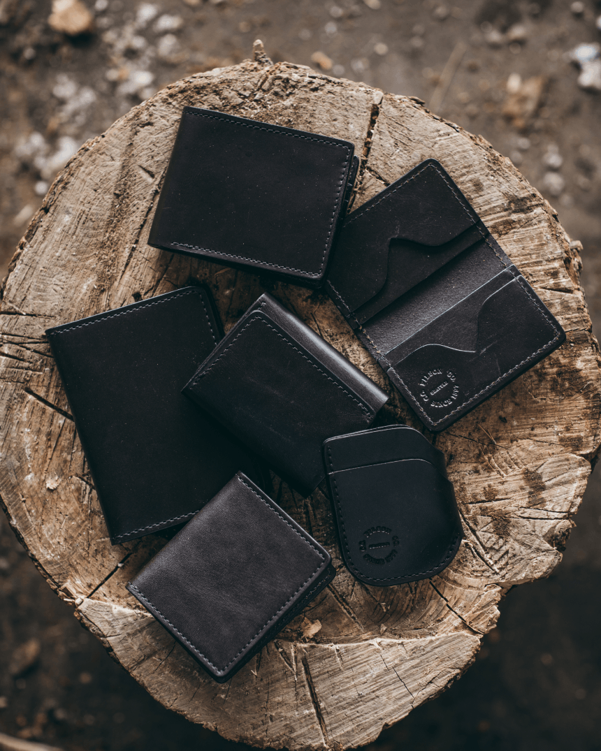 Top down of Filson wallets on a wooden stump.