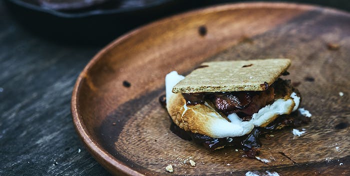 smore with bacon on a wooden plate